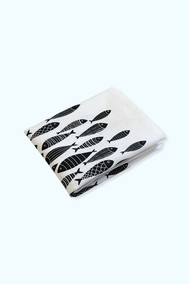 I hopvikt vit kökshandduk med illustrationer på många olika svarta fiskar och Djurens Rätts logga