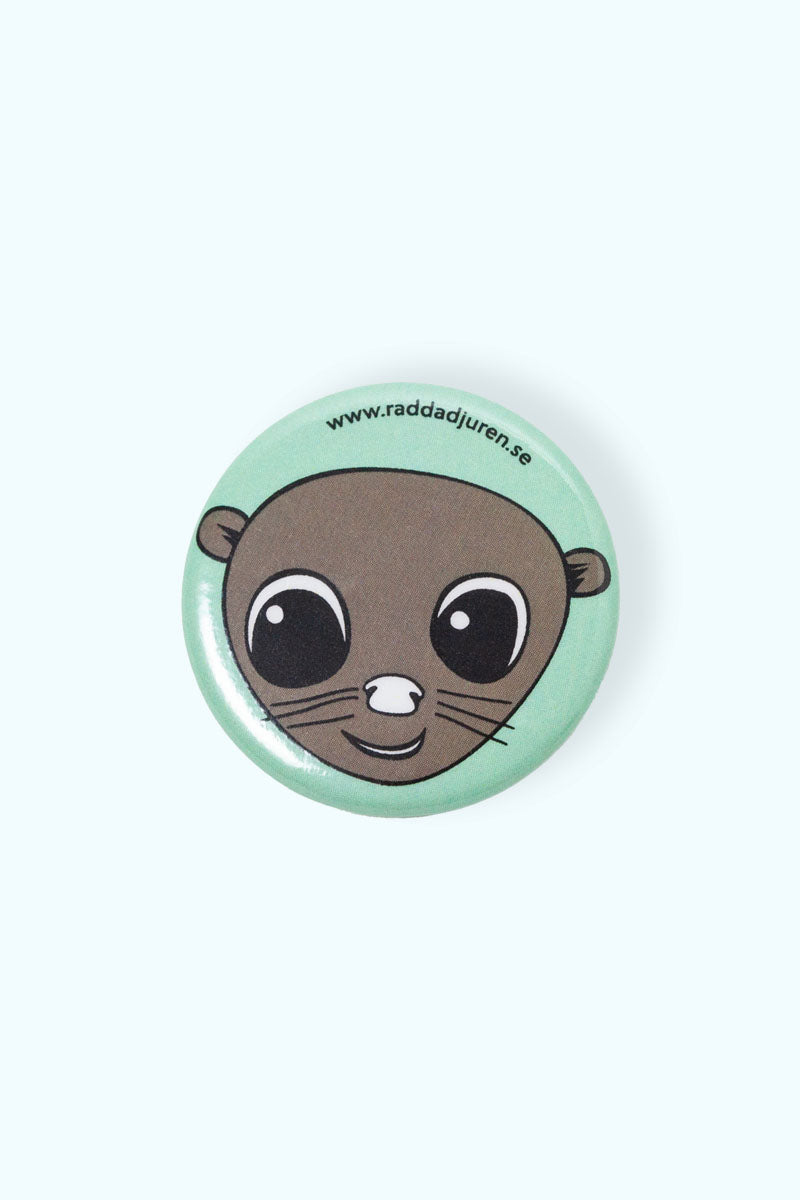Grön pin med illustration av en mink och Rädda Djuren-klubben loggan