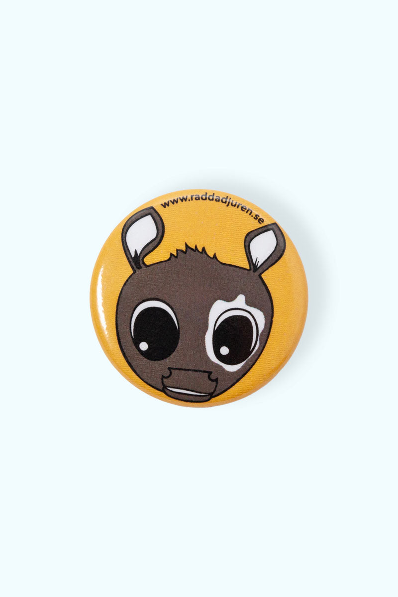 Orange pin med illustration av en ko och Rädda Djuren-klubben loggan